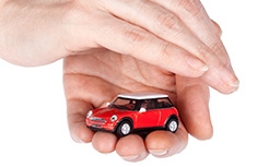Main protégeant une voiture miniature