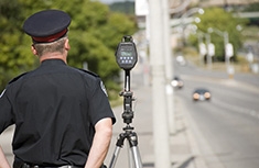 Policier procédant à des contrôles radars au bord d'une voie rapide