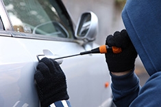 Homme entrain de forcer l'ouverture d'une voiture