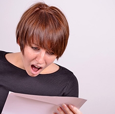 Femme surprise face à un feuille de papier